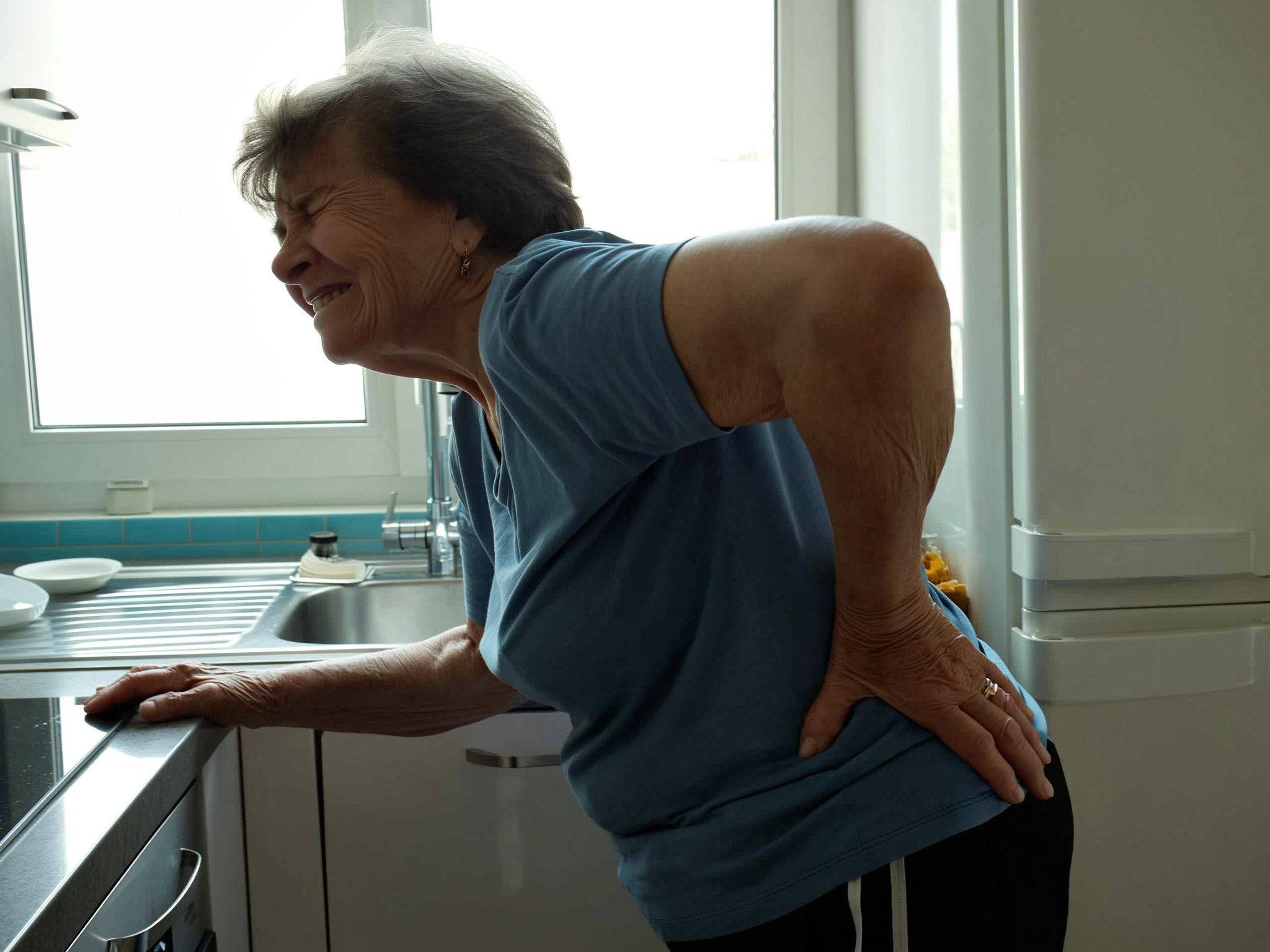 Woman struggling with back pain during morning routine